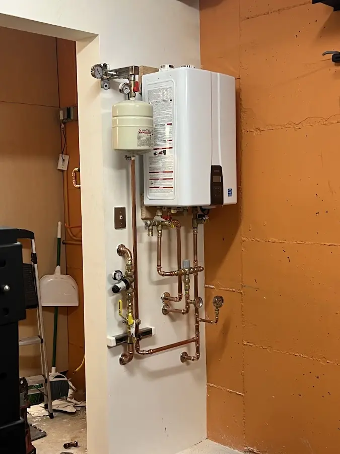 Plumbing technician inspecting water heater connections in Cherry Valley